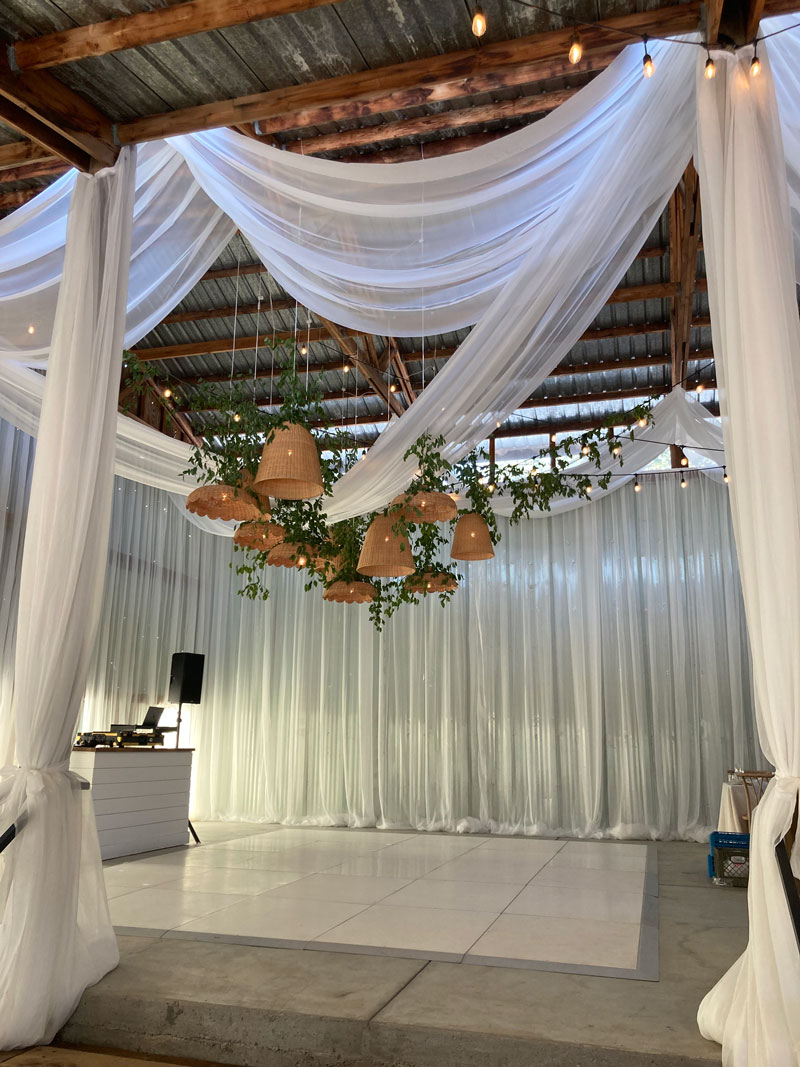 fabric, vines and lights decorate inside of barn