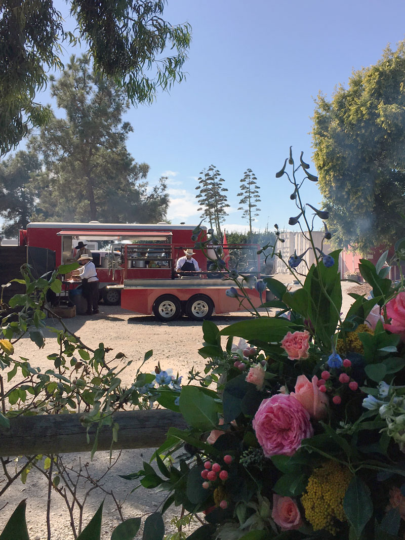 Red trailer and grill in the background behind flower display