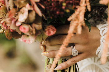 bride's hands holding bouquet of flowers