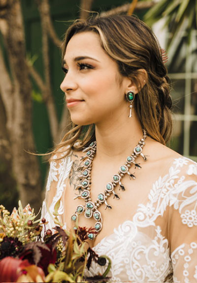 Beautiful Bride wearing squash blossom necklace holding floral bouquet