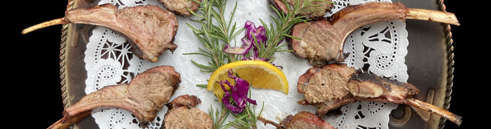 platter of lamb chops with orchid and rosemary in center