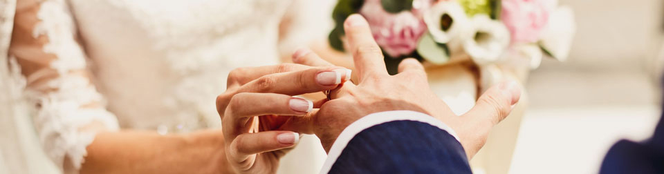 bride slids ring on grooms finger